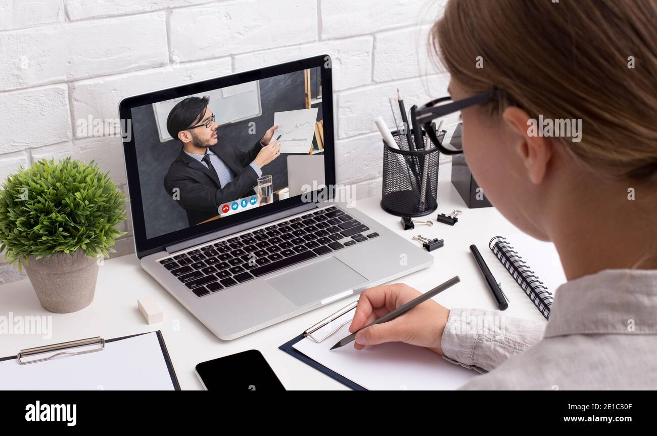 Femme à l'ordinateur portable ayant la consultation en ligne d'affaires dans le bureau Banque D'Images