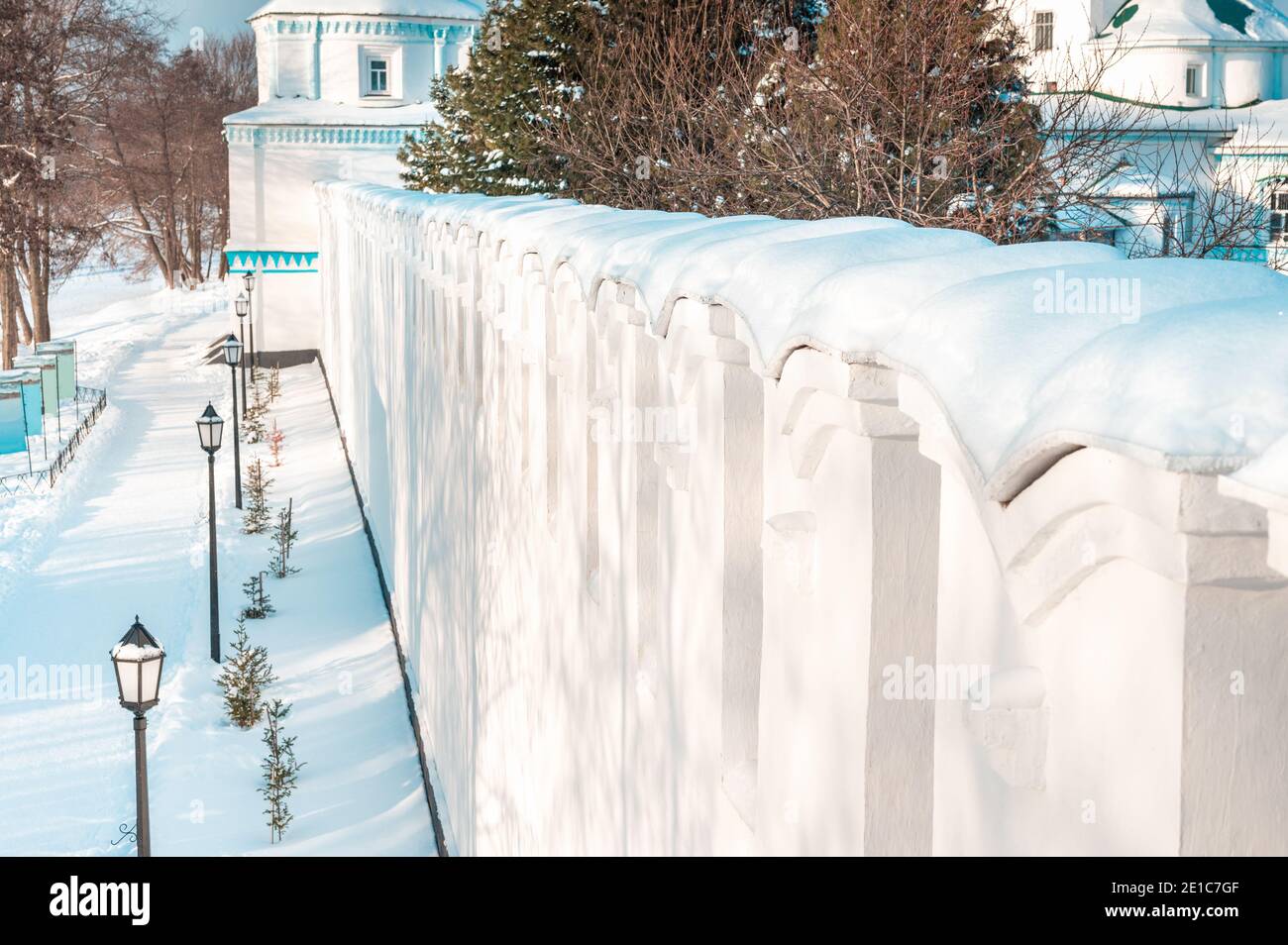 Clôture en bois recouverte de neige en hiver nuageux le jour après la chute de neige. Saison d'hiver, concept temps froid. Après un transfert d'hiver, de profondes perdrides de neige s'entaillaient en hauteur Banque D'Images