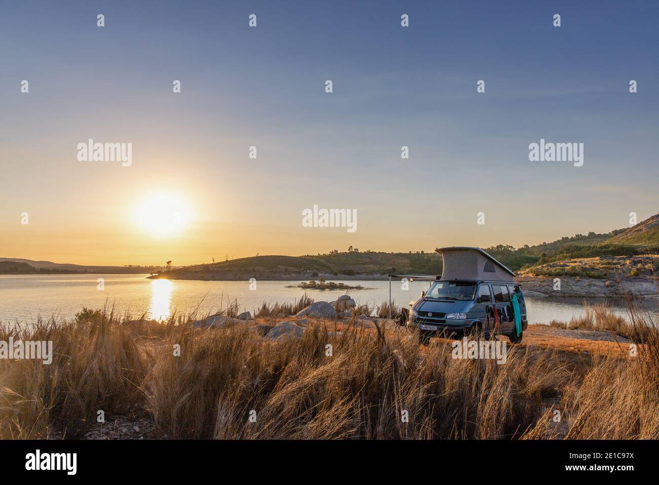 Lever du soleil pendant le camping en forêt avec Offroad Camper VW T4 Syncro Californie Capervan en autocar avec toit escamotable au barrage du lac Alto Rabagão - Nord du Portugal Banque D'Images