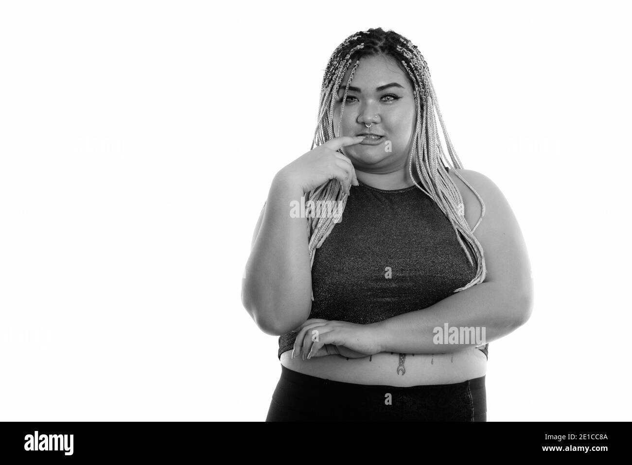 Studio shot of young Asian woman biting fingernail gras Banque D'Images