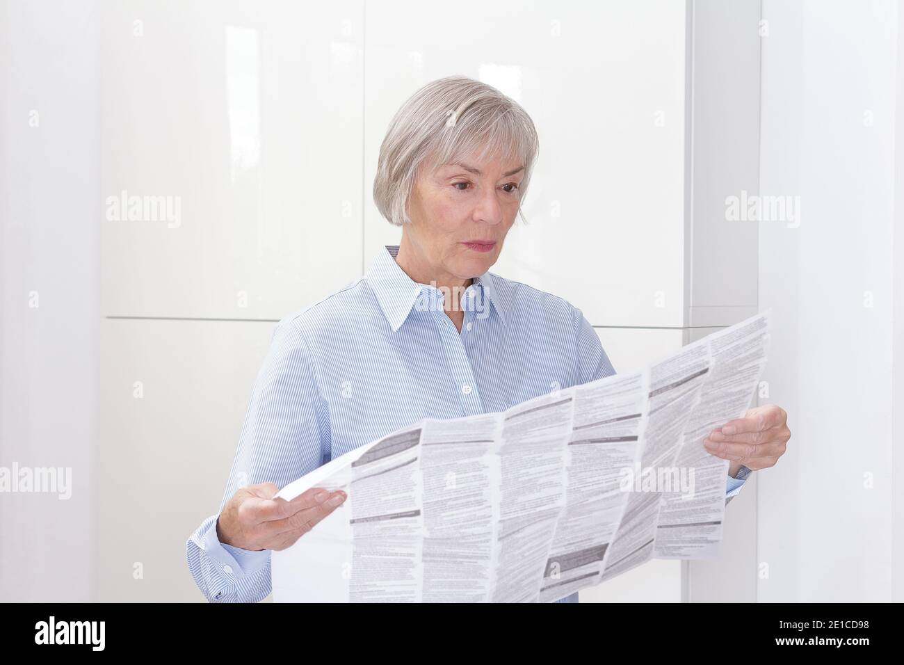 Femme âgée avec un énorme feuillet d'information de patient pour son médicament prescrit, l'espace de copie. Banque D'Images
