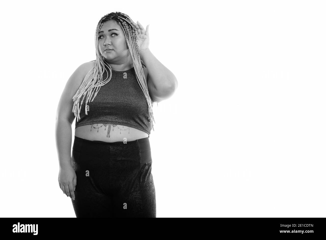 Studio shot of young woman standing asiatique de graisse lors de l'écoute Banque D'Images