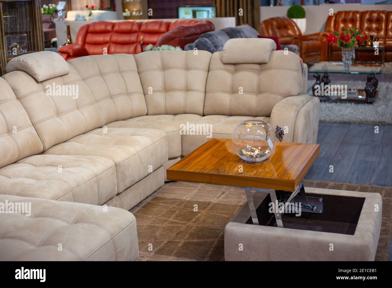 L'intérieur de la pièce. Grand canapé beige avec coutures, canapé-table avec vase. Magasin de meubles. Banque D'Images