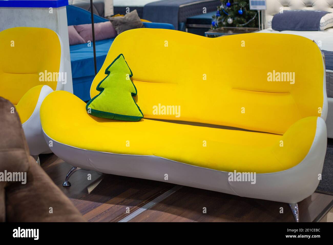 Canapé compact jaune avec un oreiller en forme de chevrons. Intérieur de la chambre. Magasin de meubles. Banque D'Images