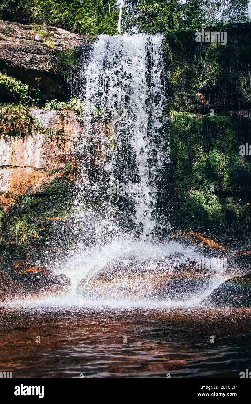 Cascade de Pekelny sur la rivière Jedlova dans les belles forêts des montagnes de Jizera dans le paysage tchèque. Ci-dessous se trouve un bel arc-en-ciel conteneuin Banque D'Images