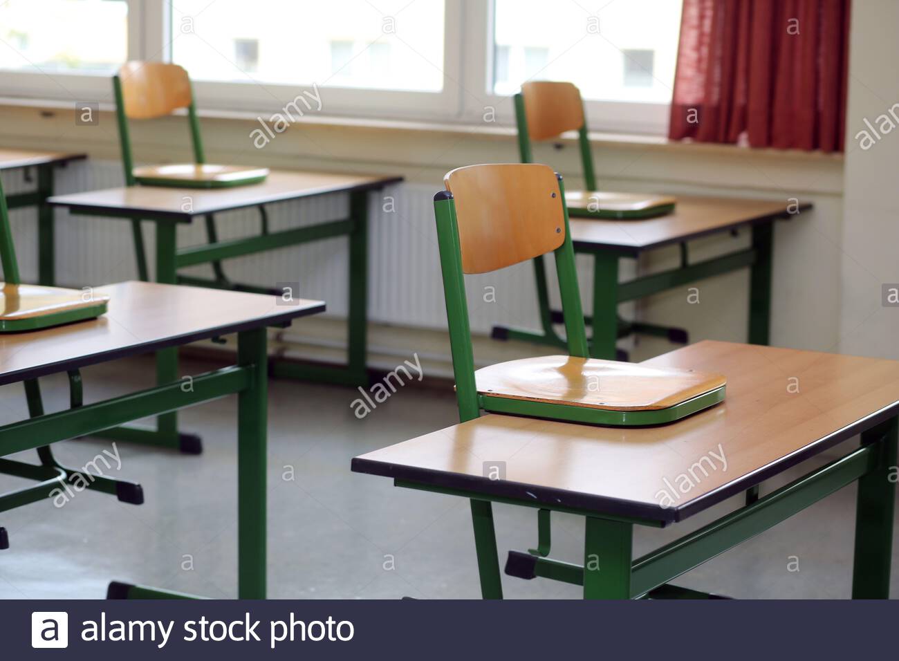 Un ensemble de chaises sur les dépôts scolaires dans une salle de classe déserte pendant que la crise de Corona continue. Banque D'Images