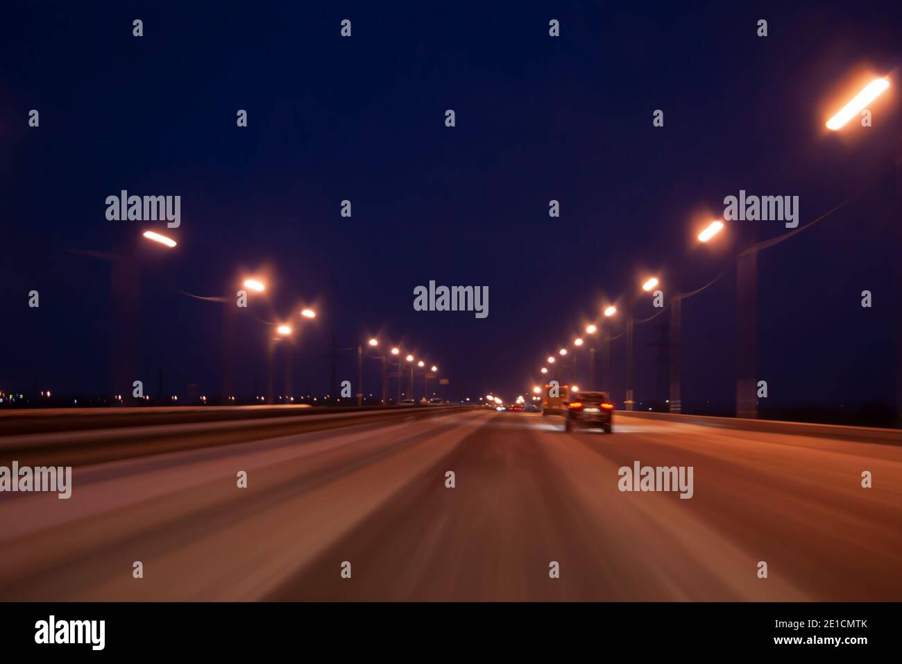 Autoroute de nuit en hiver. Des phares lumineux dans l'obscurité, le mouvement des voitures du spectateur Banque D'Images