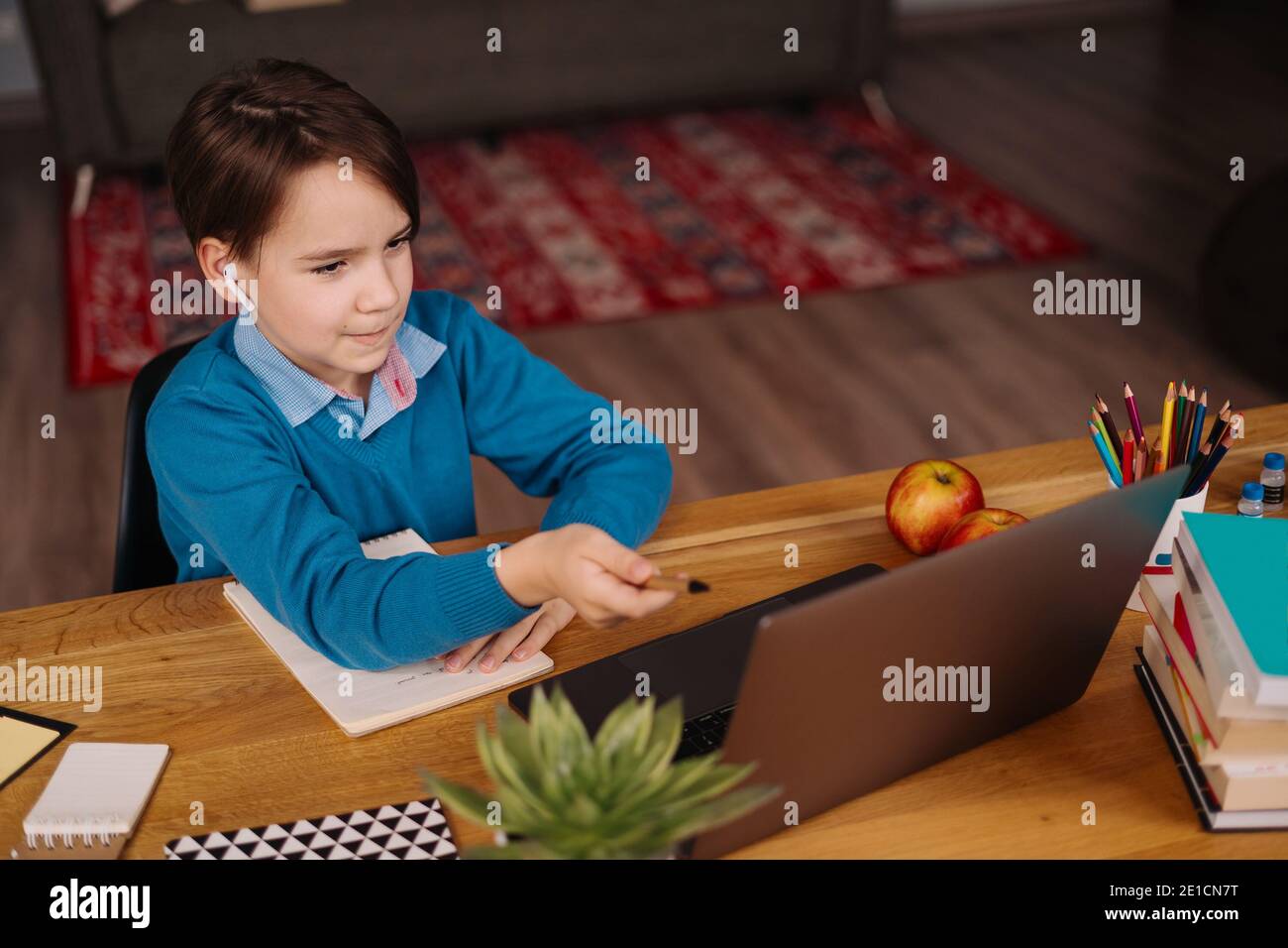 Un garçon de Preteen utilise un ordinateur portable pour faire des cours en ligne. E-Education à distance, enseignement à domicile. Banque D'Images