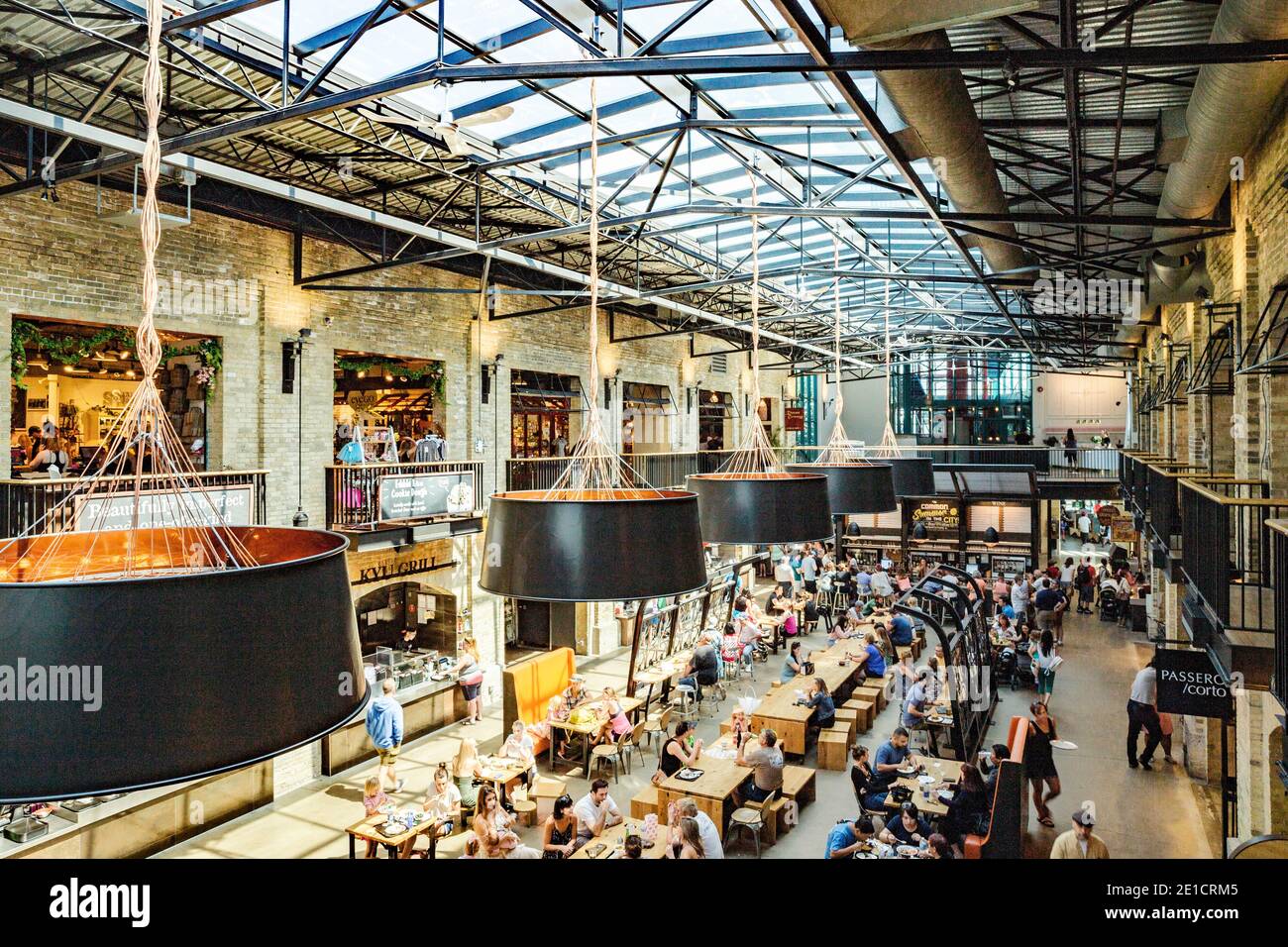 Sous le toit du marché de l'alimentation et des magasins, la fourche, dans la capitale du Manitoba, Winnipeg. La maison d'hôtes au toit de verre avec les tables en bois est pleine Banque D'Images
