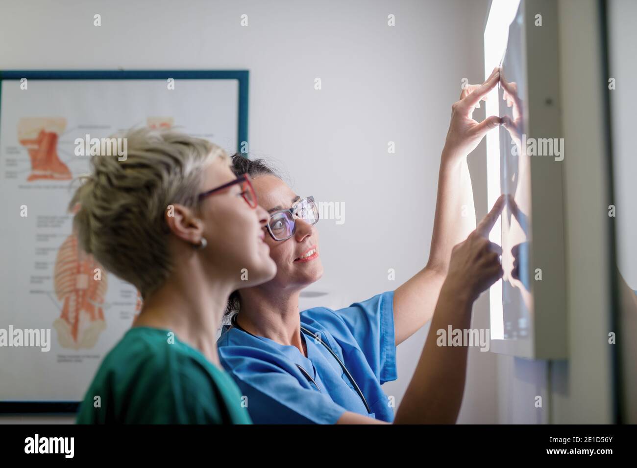 Médecin montrant à sa collègue une radiographie de l'os brisé. Banque D'Images