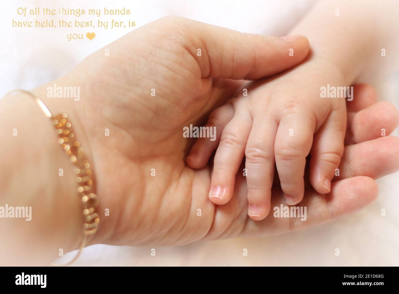 Une mère portant un bracelet de maman tenant la main de son bébé. Banque D'Images