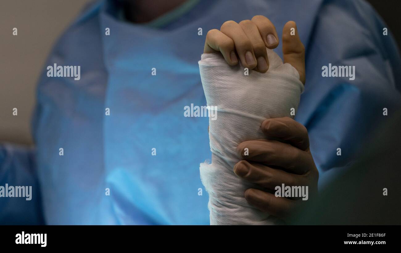 Un chirurgien tient le poignet d'un patient opéré la salle d'opération Banque D'Images