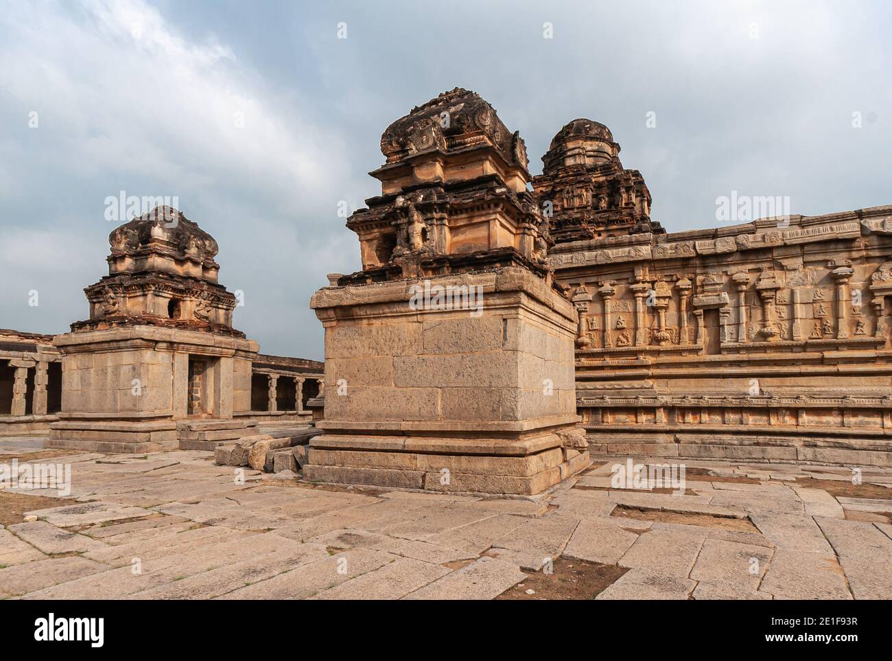 Hampi, Karnataka, Inde - 5 novembre 2013 : temple de Sri Krishna en ruines. 2 petits sanctuaires bruns devant le bâtiment principal du temple, tous avec un front plus foncé Banque D'Images