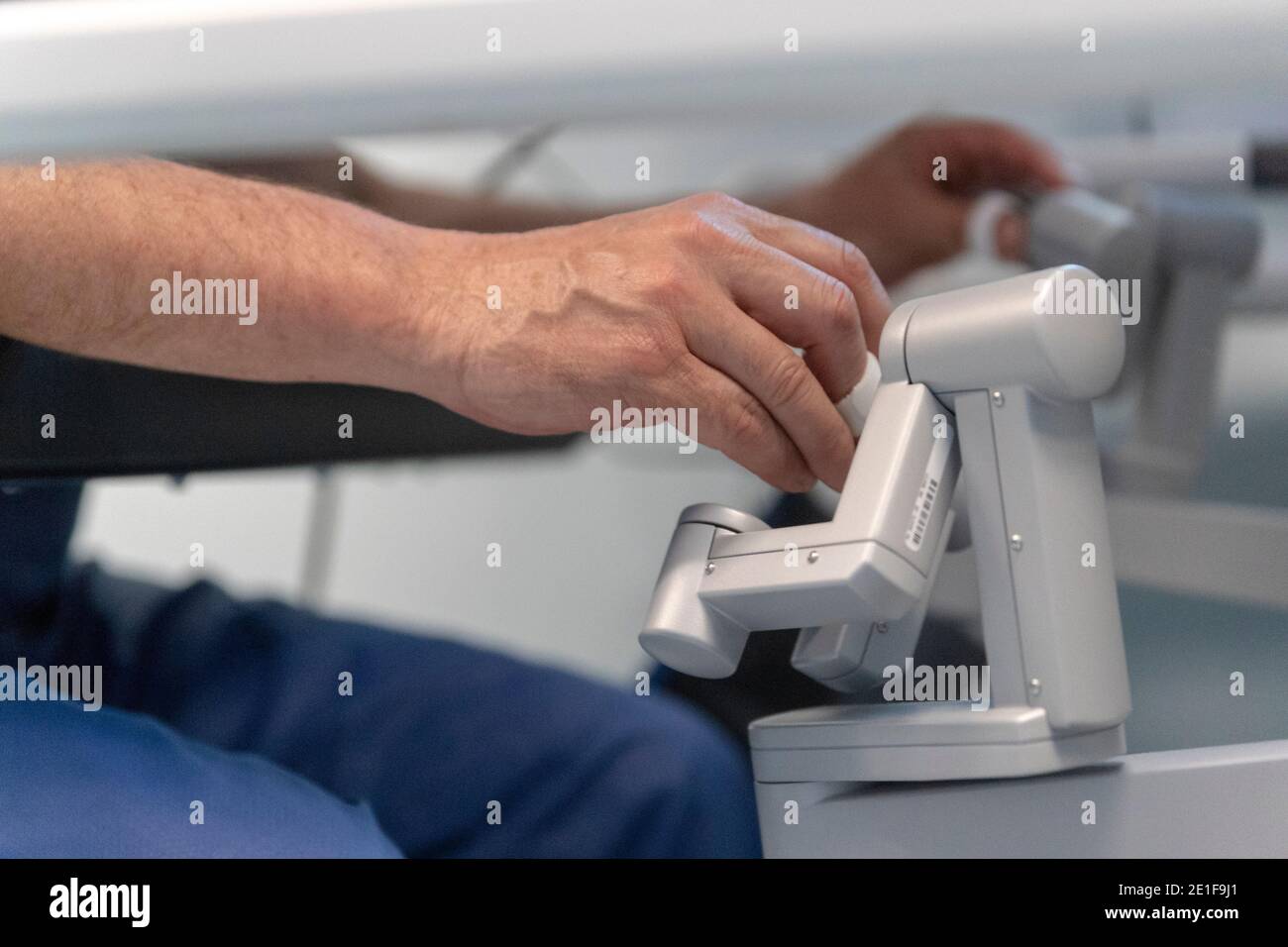 un chirurgien manipule les commandes d'un robot qui fonctionne un patient Banque D'Images