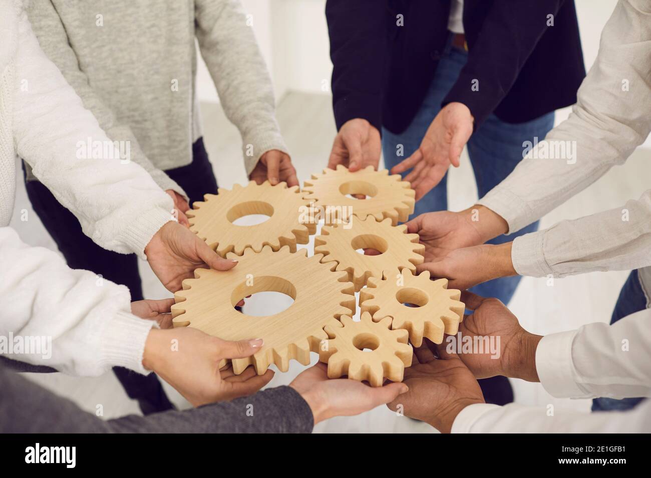 Équipe de personnes se joignant à Gears comme métaphore pour la collaboration et trouver des solutions créatives Banque D'Images