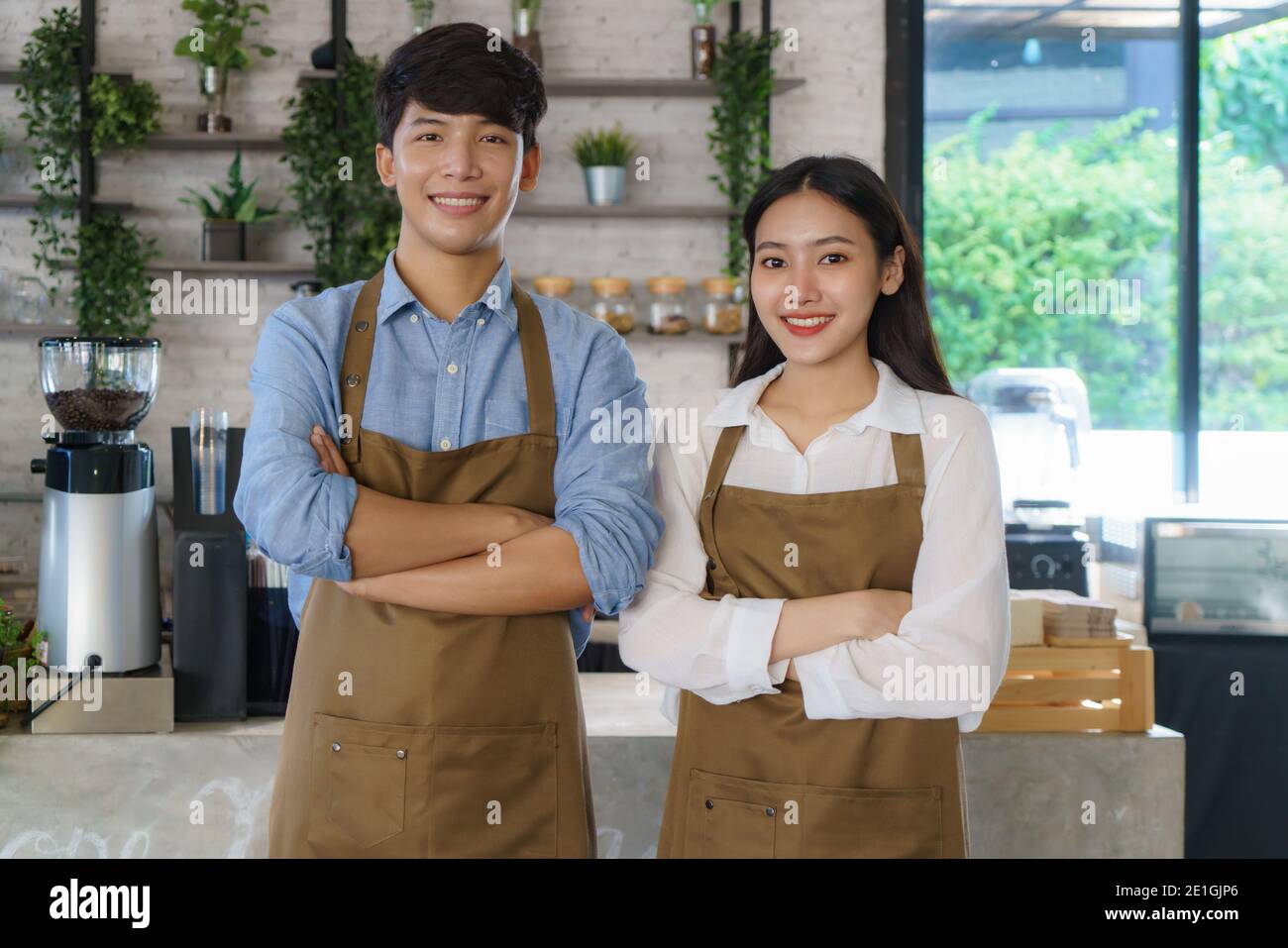 Couple asiatique Barista ou propriétaire petite entreprise dans la recherche de tablier À l'appareil photo prêt à donner le service du café au moderne café-restaurant Banque D'Images