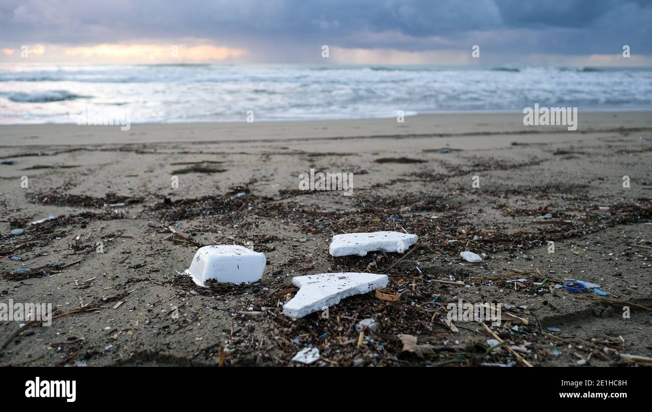 Plastique de polystyrène jeté sur la côte sale de l'océan après la tempête de mer, coucher de soleil heure Banque D'Images