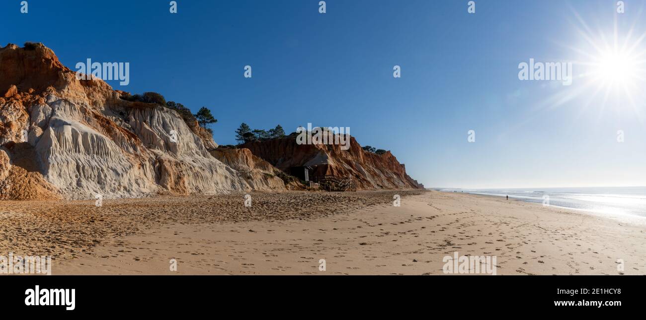 Une vue panoramique sur une large plage de sable doré vide avec des falaises de sable colorées par une journée ensoleillée Banque D'Images