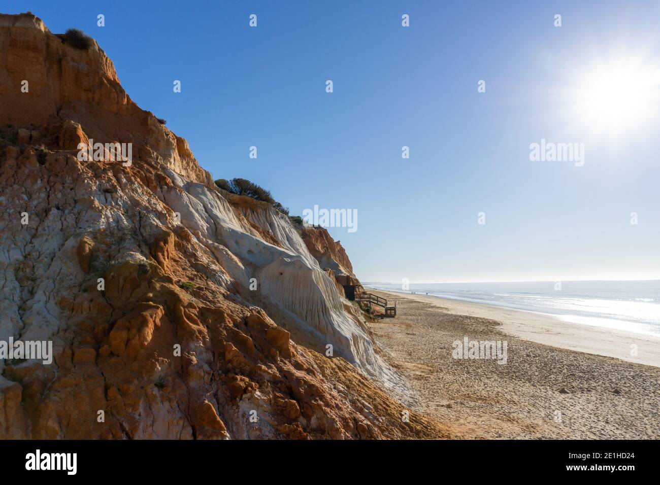 Une vue sur une grande plage de sable doré vide avec falaises de sable colorées par une journée ensoleillée Banque D'Images