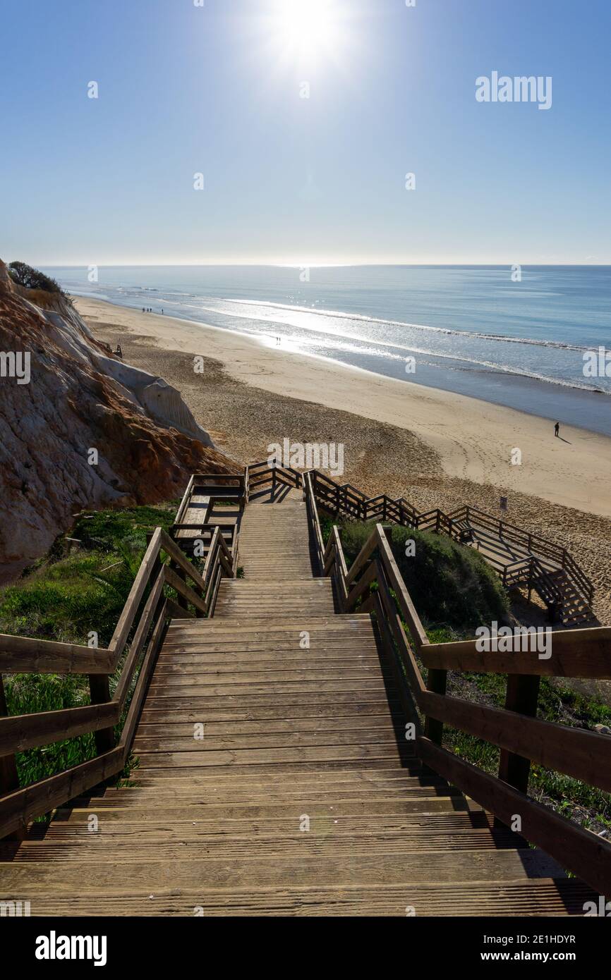 Une longue promenade en bois menant à la plage large plage dorée avec falaises de sable colorées Banque D'Images