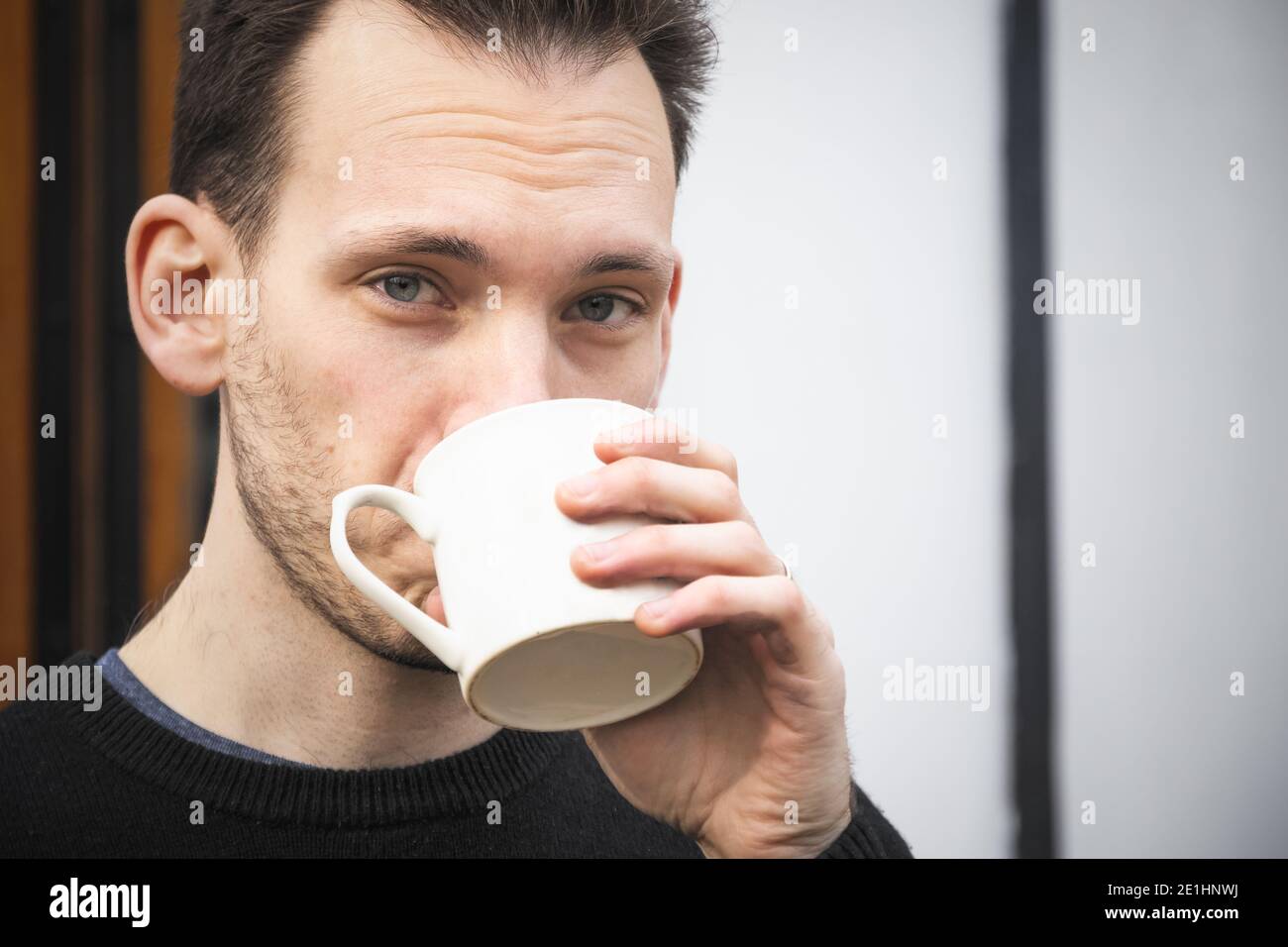 Portrait d'un homme du caucase qui boit du thé ou du café une tasse blanche Banque D'Images