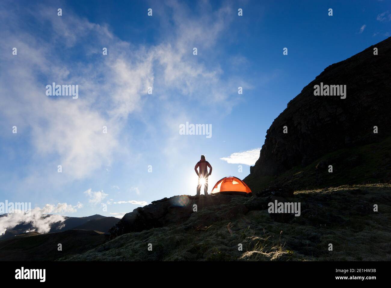 Femme debout devant tente au lever du soleil, de l'Islande Banque D'Images