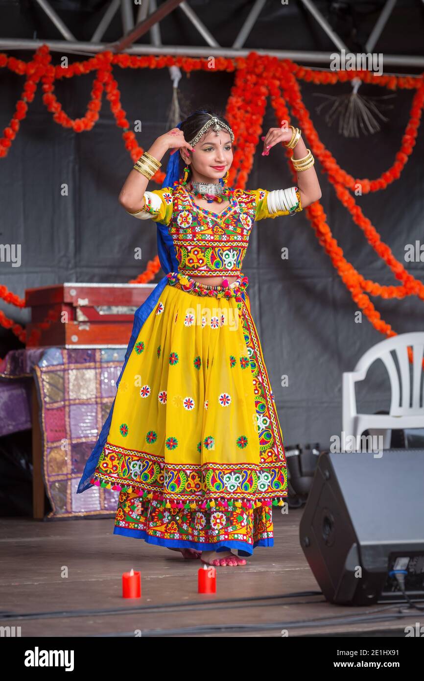 Une jeune femme indienne dans un jaune coloré sari dansant sur scène pendant Diwali, le festival hindou des lumières Banque D'Images
