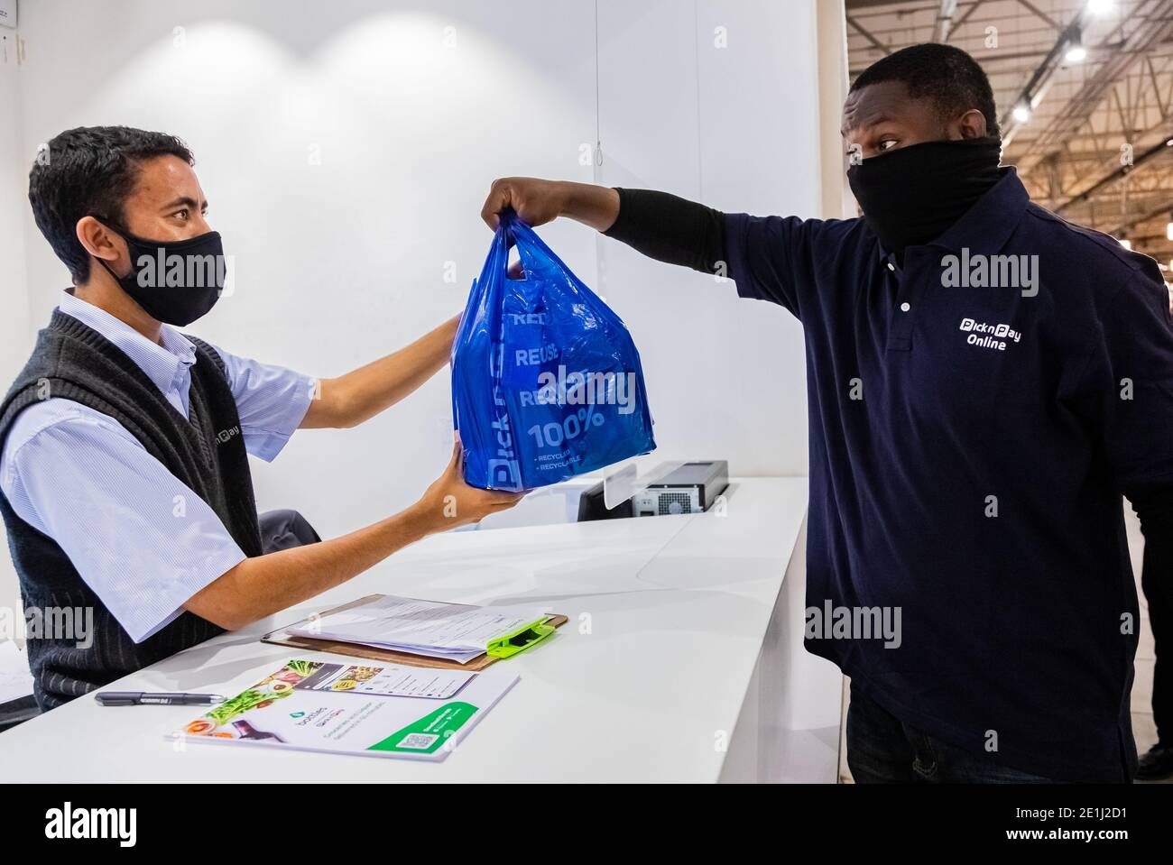 Cape Town, Afrique du Sud - 10 décembre 2020: Express Service à domicile homme de livraison de la collecte de la commande du personnel au comptoir à l'intérieur de l'épicerie locale Pick n Pay Banque D'Images