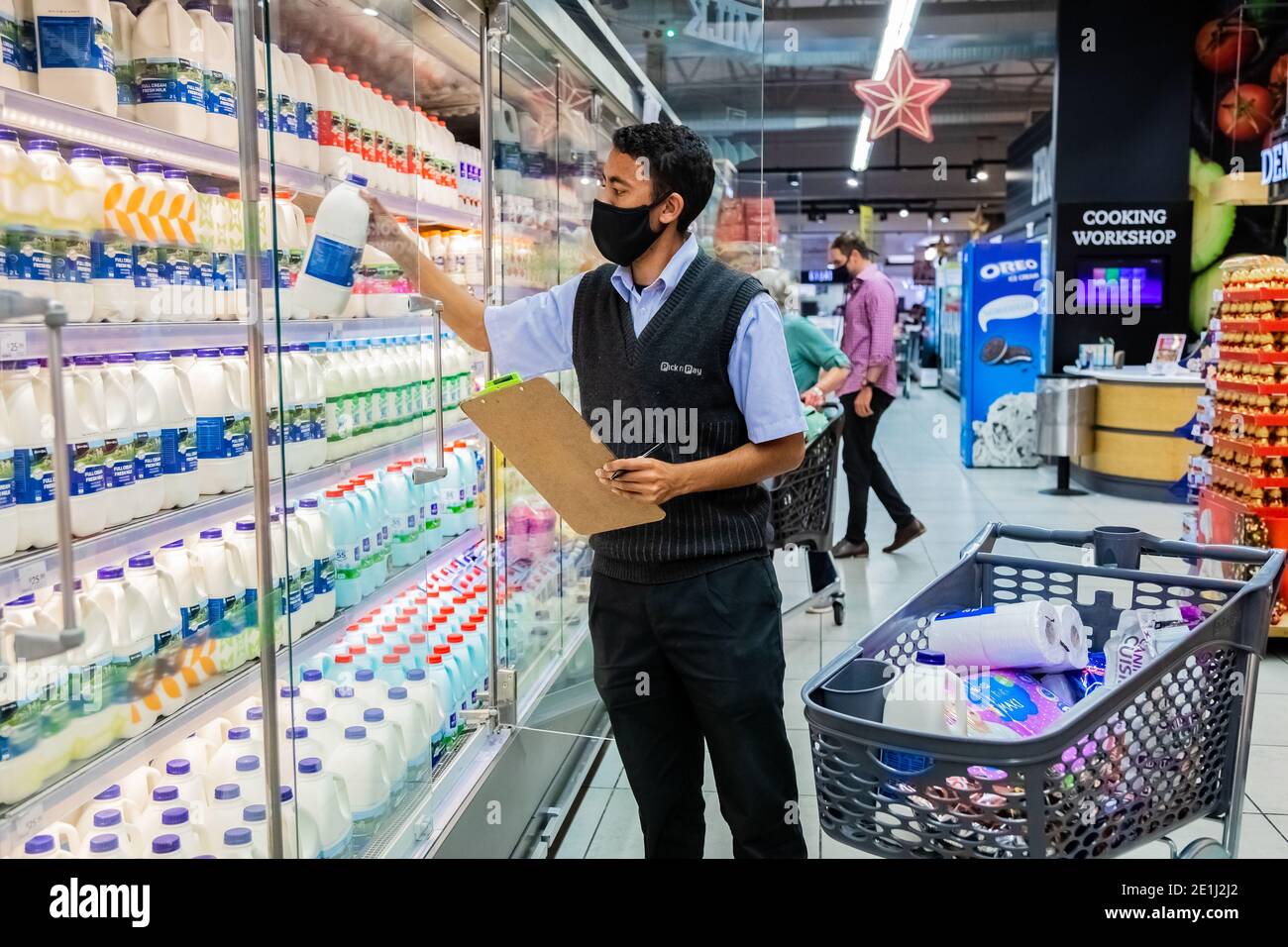 Cape Town, Afrique du Sud - 10 décembre 2020 : membre du personnel qui cueille les produits d'épicerie de l'étagère pour un service de livraison express à domicile au service local Pick n Pay su Banque D'Images