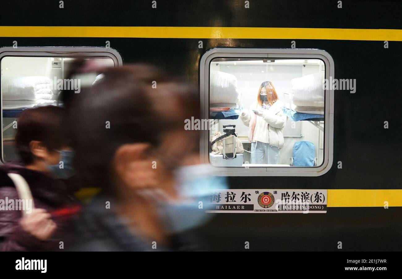 (210107) -- HARBIN, le 7 janvier 2021 (Xinhua) -- les passagers prennent le train K7093 en direction de Hailar, région autonome de la Mongolie intérieure de la Chine du nord, à la gare de Harbin, dans la province de Heilongjiang, au nord-est de la Chine, le 6 janvier 2021. Le train n° K7093/4, qui relie Harbin et Hailar, parcourt une distance de 1,320 kilomètres et s'arrête à 52 stations pendant le trajet d'environ 26 heures. Le train s'arrête toutes les 30 minutes en moyenne à cause de tant d'arrêts et est connu comme le train le plus lent dans la région forestière entre les deux destinations. Ayant fonctionné pendant plus de 30 ans, les installations du train ont vu u Banque D'Images