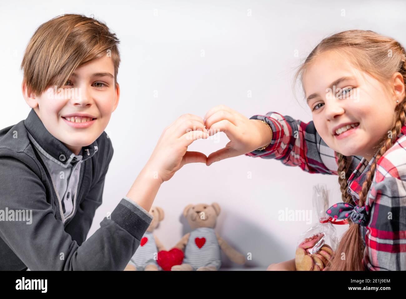 Forme de coeur faite de mains de garçon et de fille bien-aimée, Saint-Valentin. Souriant beauté ados heureux Banque D'Images