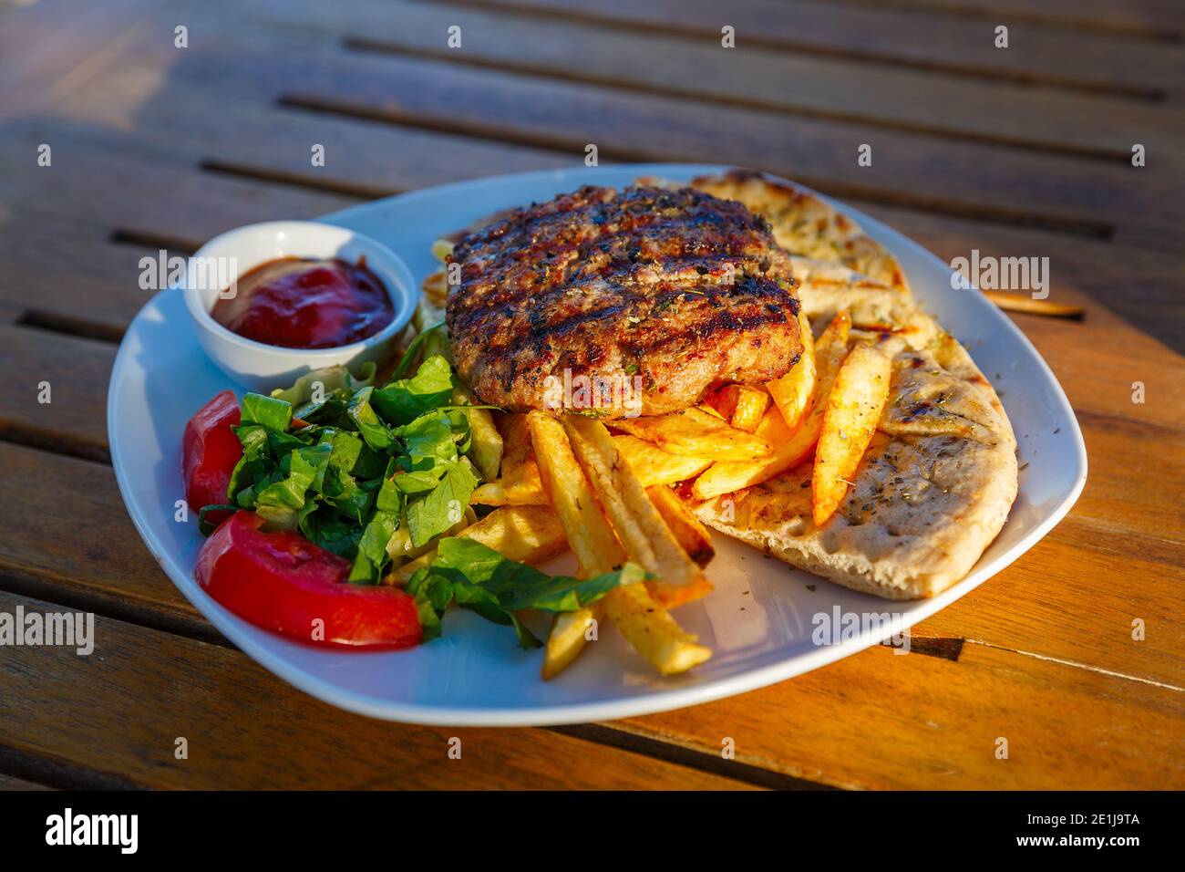 Hamburger et frites dans une assiette sur un bois tableau Banque D'Images