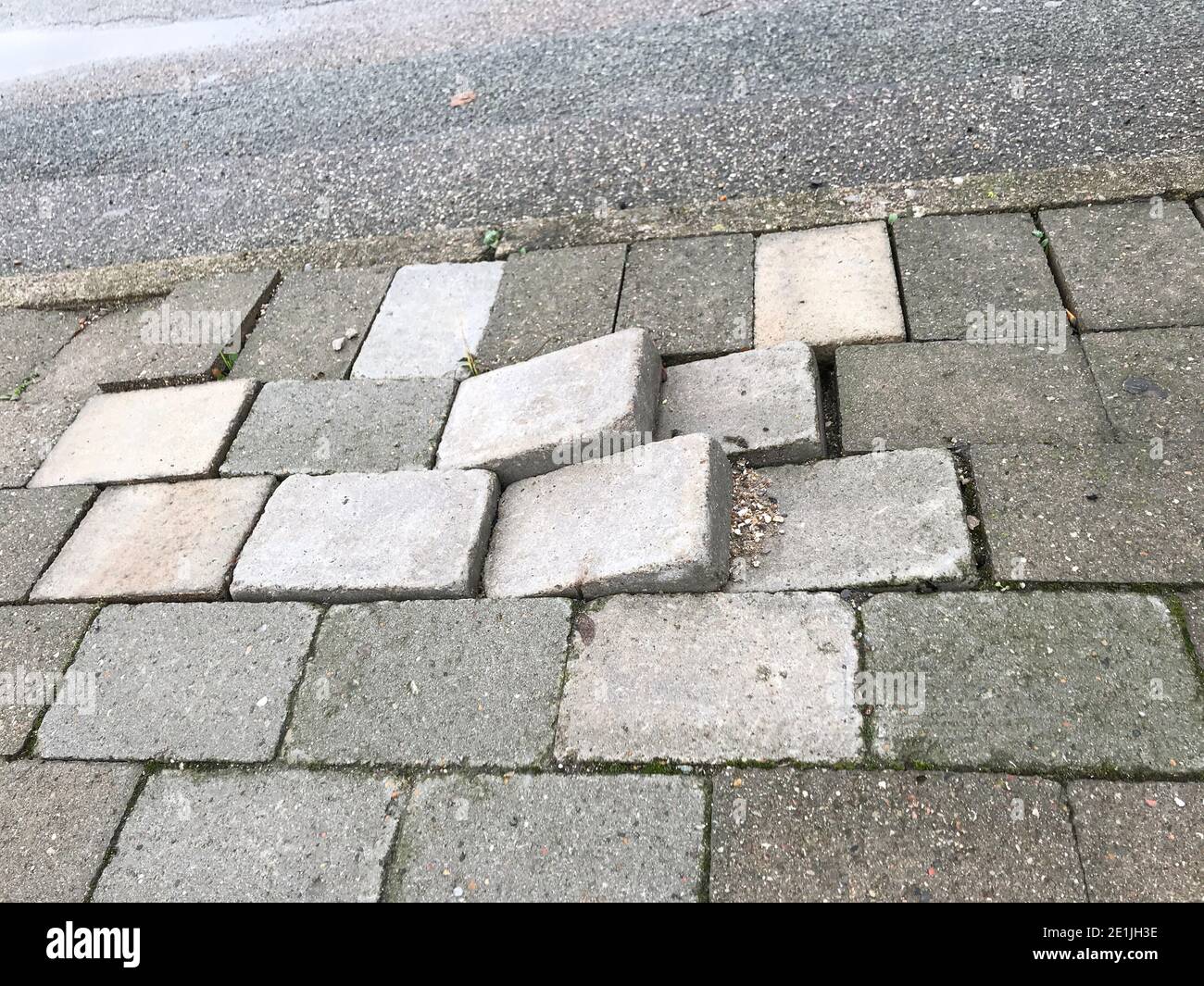 Les carreaux de trottoir pour piétons sont inégaux en raison du manque de l'entretien peut causer un danger pour les piétons et la circulation Banque D'Images