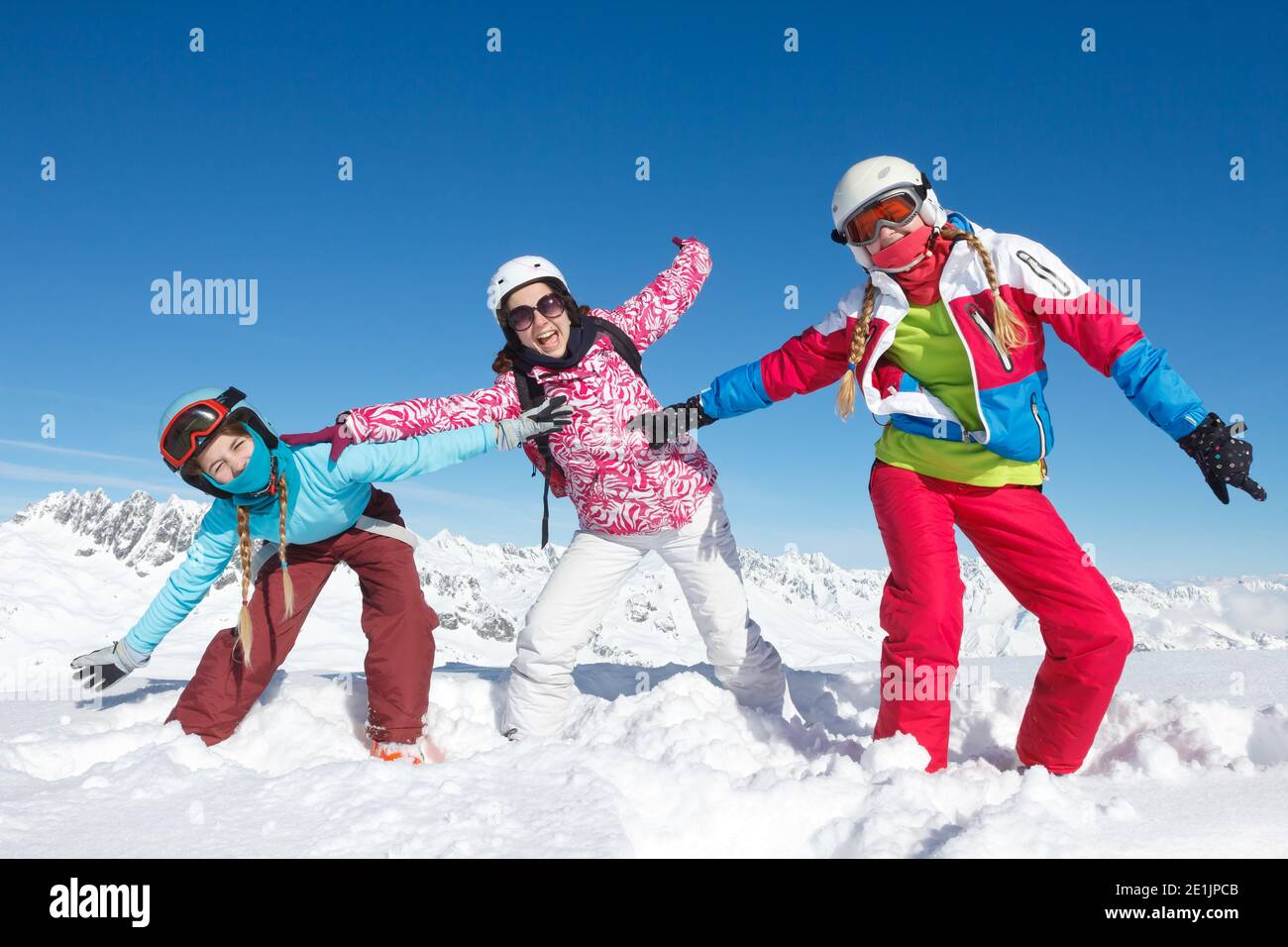 Trois filles en vacances d'hiver dans les Alpes posant dans la neige sur les pistes de ski. Activités amusantes dans la neige Banque D'Images