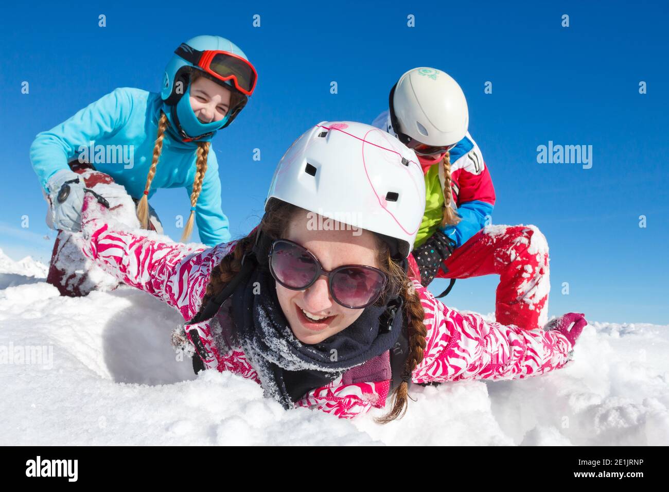 Bonne famille en vacances avec le ciel bleu et coloré vêtements jouant dans la neige fraîche sur les pistes de ski de haute savoie Banque D'Images
