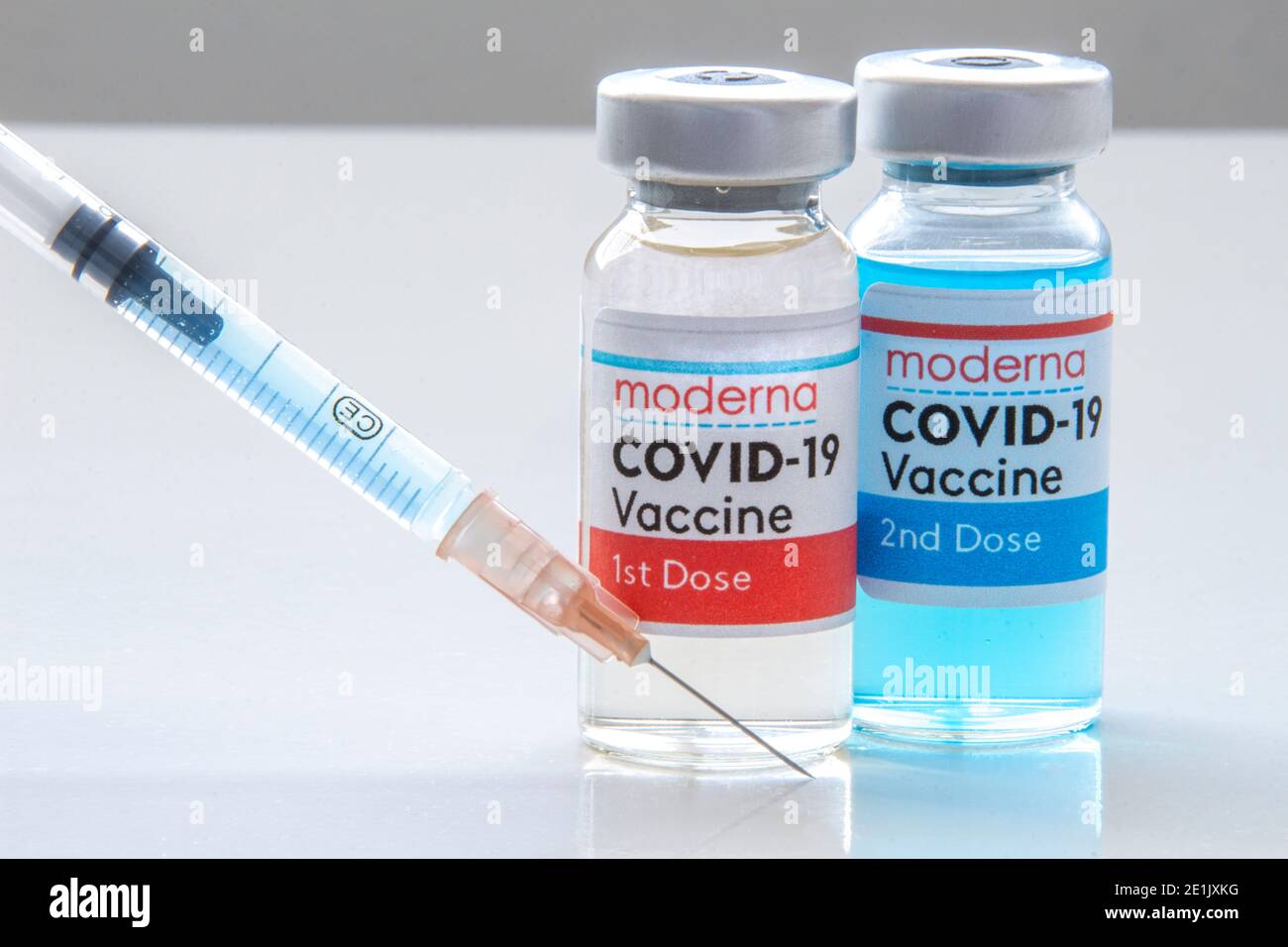 Calgary, Alberta, Canada. 27 novembre 2020. Une 1ère dose Moderna et une 2ème dose de vaccin Covid-19 sur un flacon et une seringue d'injection sur une languette blanche Banque D'Images