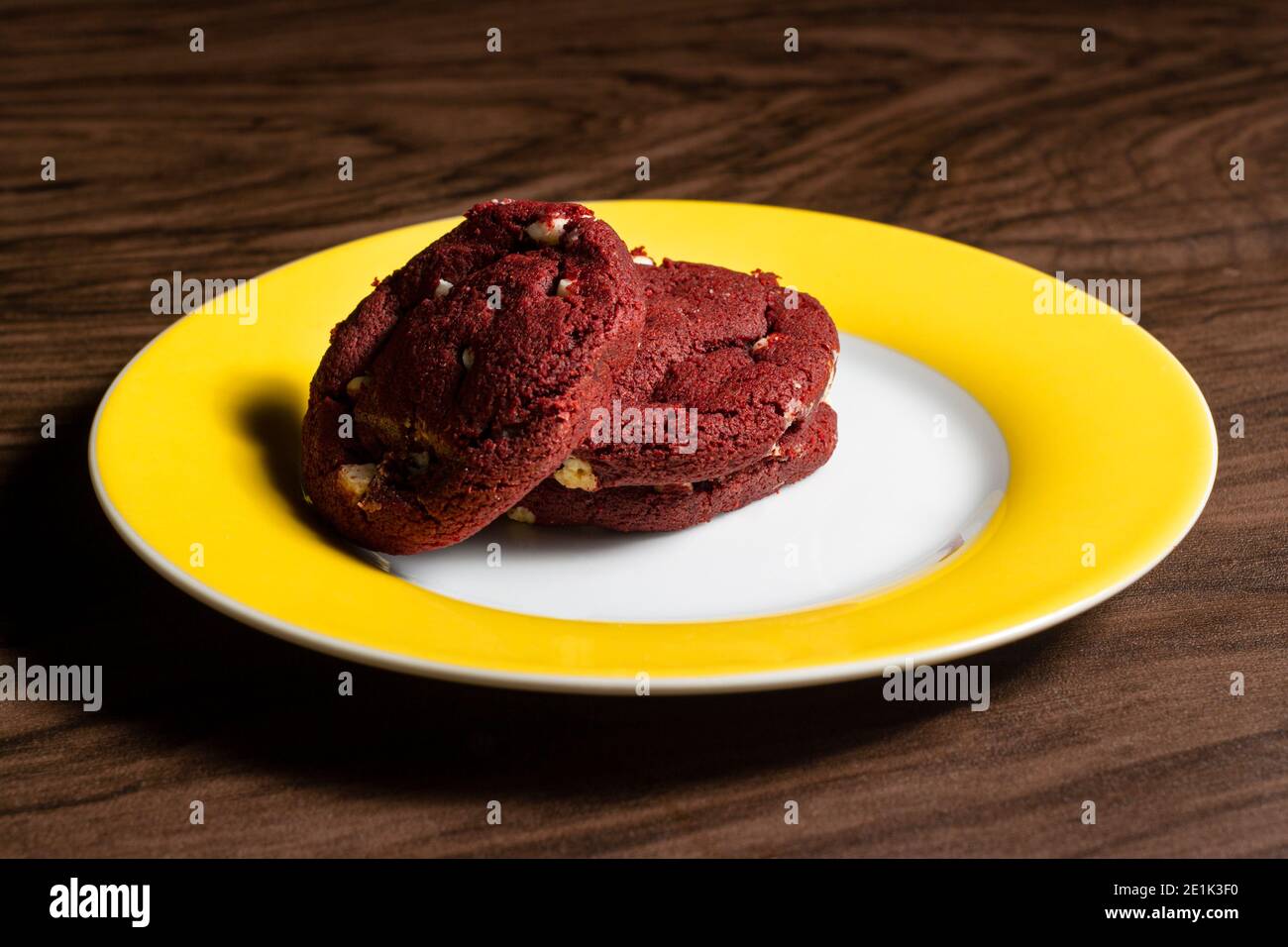 Biscuit en velours rouge avec chocolat blanc sur la table en bois sombre. Banque D'Images