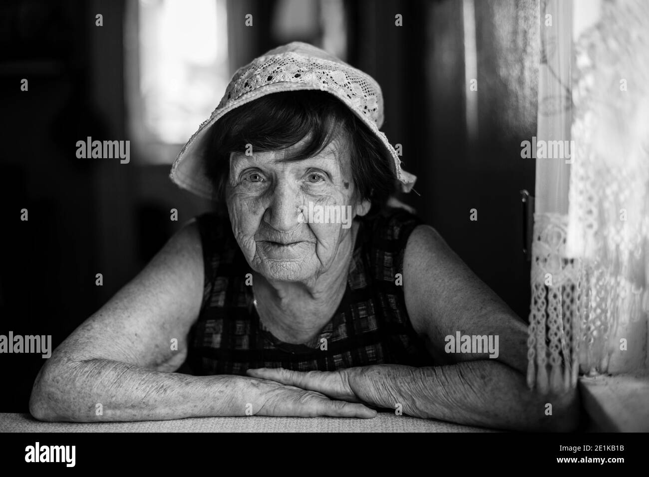 Portrait d'une vieille femme dans sa maison. Photo en noir et blanc. Banque D'Images