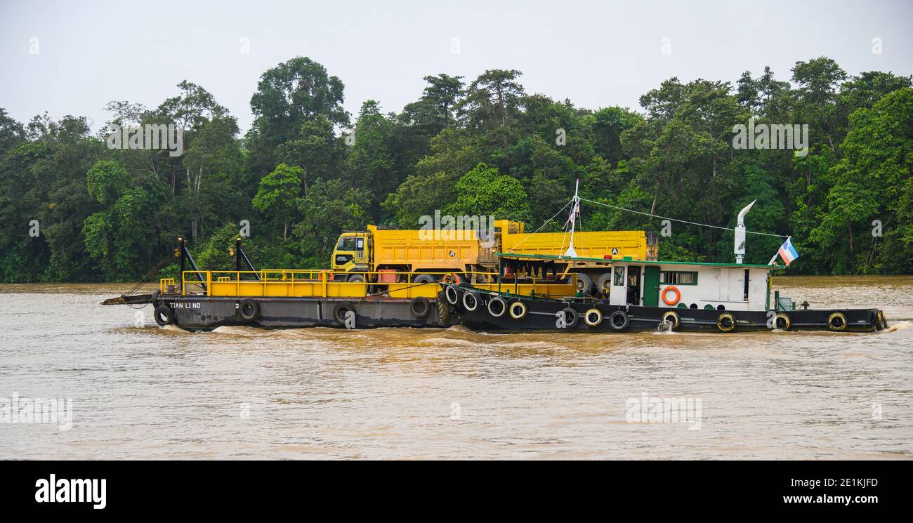 Remorqueur poussant une barge avec une grande décharge jaune Descendez la rivière Kinabatangan en camion Banque D'Images