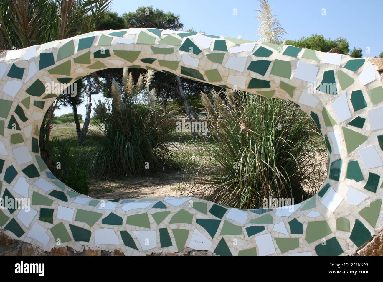 Un mur entourant un parc à Guardamar sur la Costa Blanca, Espagne. Créé à l'aide de tuiles cassées pour former une mosaïque en béton blanc. Banque D'Images