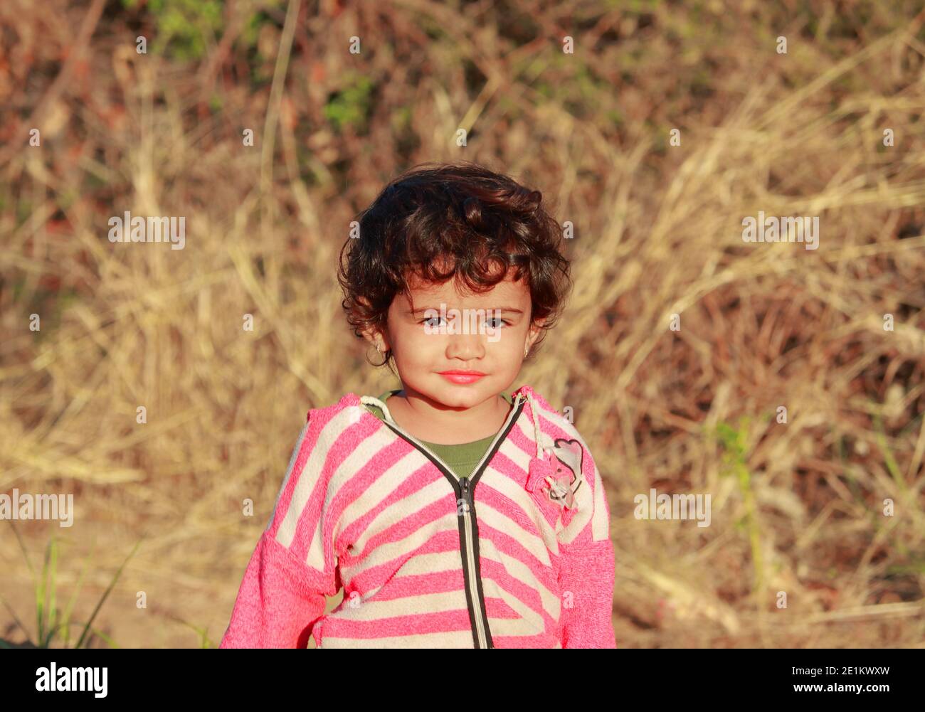 Photo indienne belle petite fille masculine dans laquelle l'enfant se tient dehors dans la nature et hors de la mise au point arrière-plan avec photo portrait de l'enfant indien , Banque D'Images