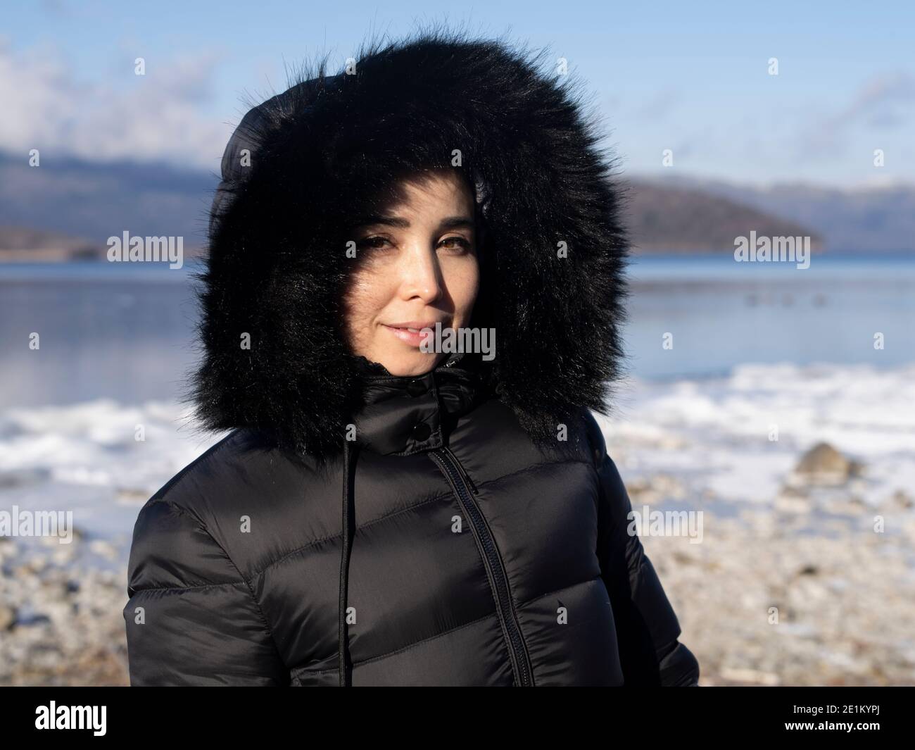 Femme portant une fausse fourrure noire et une veste de duvet synthétique au lac Kussharo 屈斜路湖, au parc national d'Akan du lac Kussharo-ko caldera, à Hokkaido, au Japon. Banque D'Images