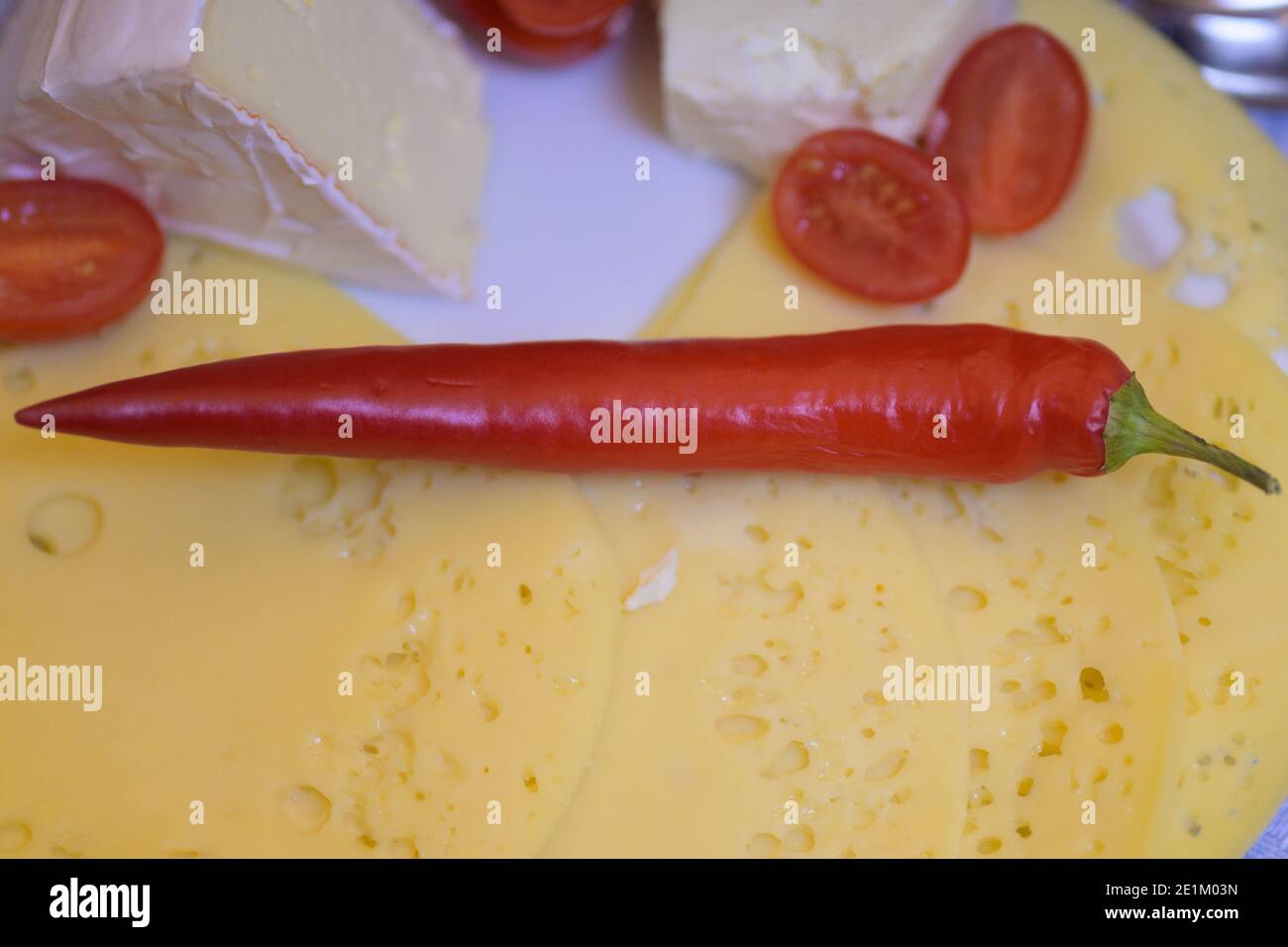Savoureux plateau de fromages avec trois fromages assortis et frais entiers piment sur la tomate hachée en gros plan Banque D'Images