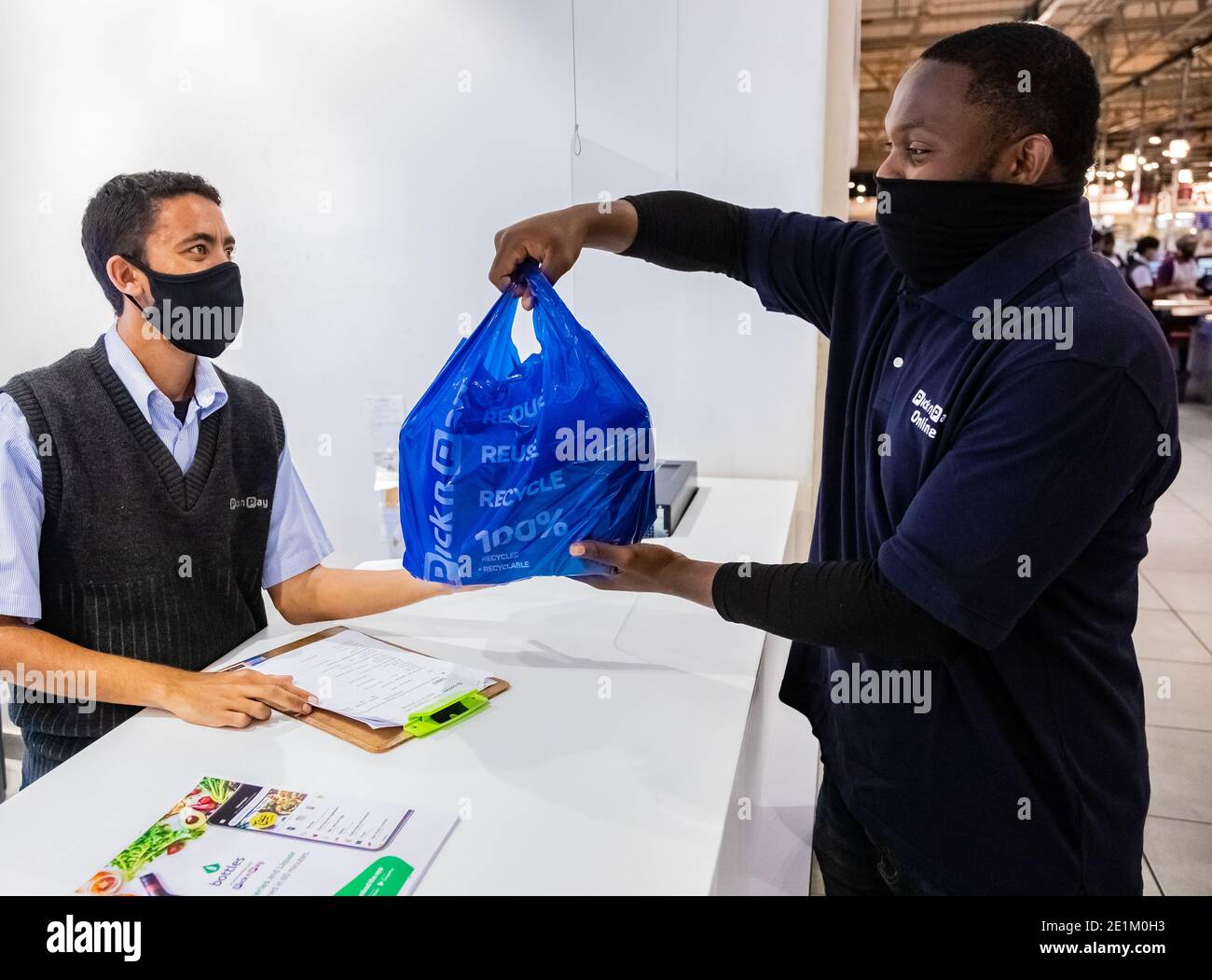 Cape Town, Afrique du Sud - 10 décembre 2020: Express Service à domicile homme de livraison de la collecte de la commande du personnel au comptoir à l'intérieur de l'épicerie locale Pick n Pay Banque D'Images