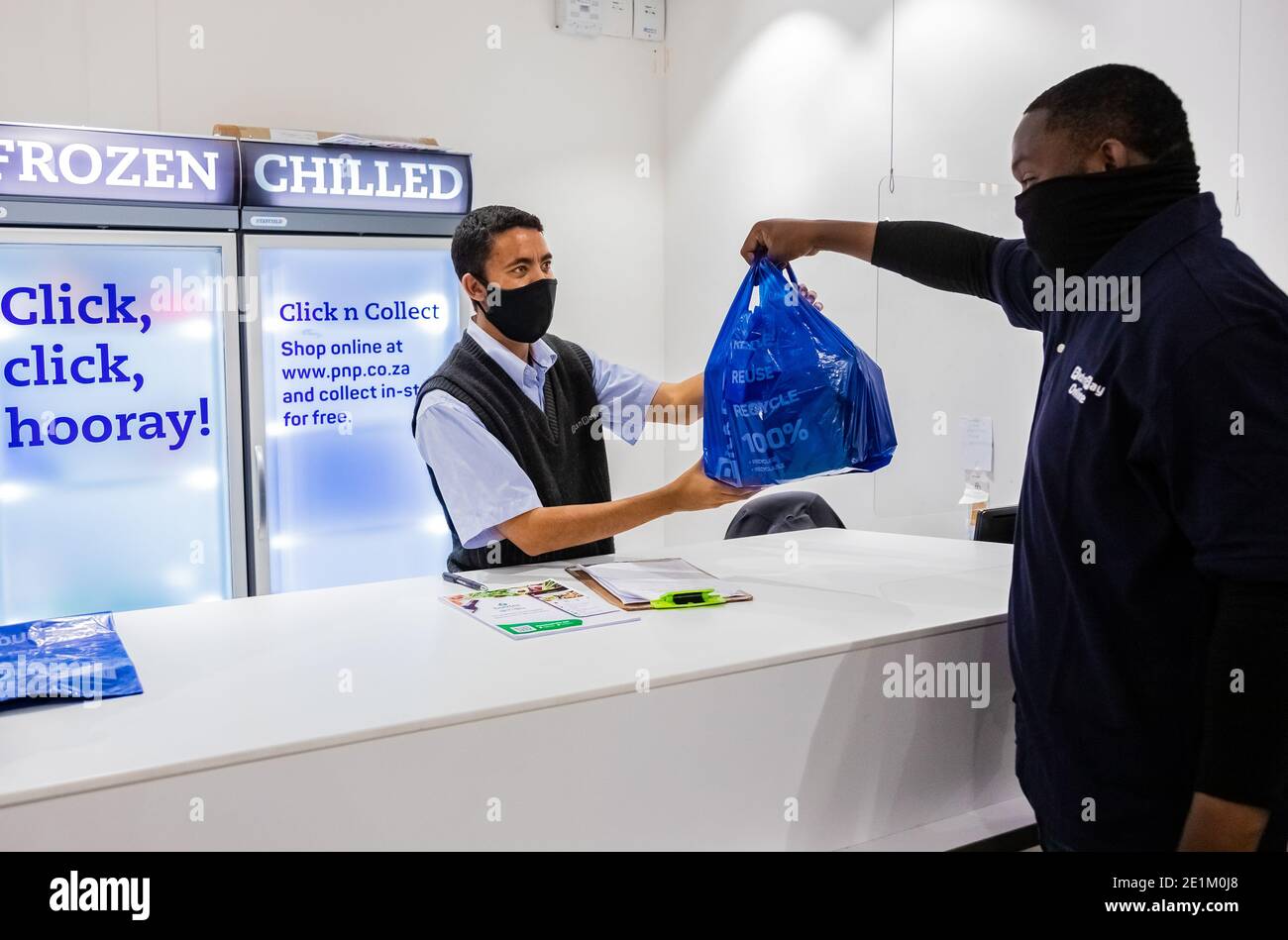 Cape Town, Afrique du Sud - 10 décembre 2020: Express Service à domicile homme de livraison de la collecte de la commande du personnel au comptoir à l'intérieur de l'épicerie locale Pick n Pay Banque D'Images