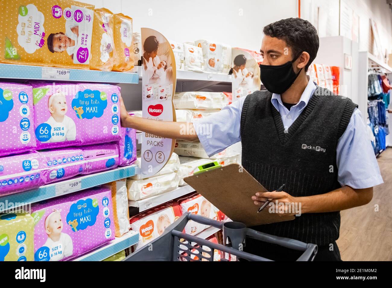 Cape Town, Afrique du Sud - 10 décembre 2020 : membre du personnel qui cueille les produits d'épicerie de l'étagère pour un service de livraison express à domicile au service local Pick n Pay su Banque D'Images