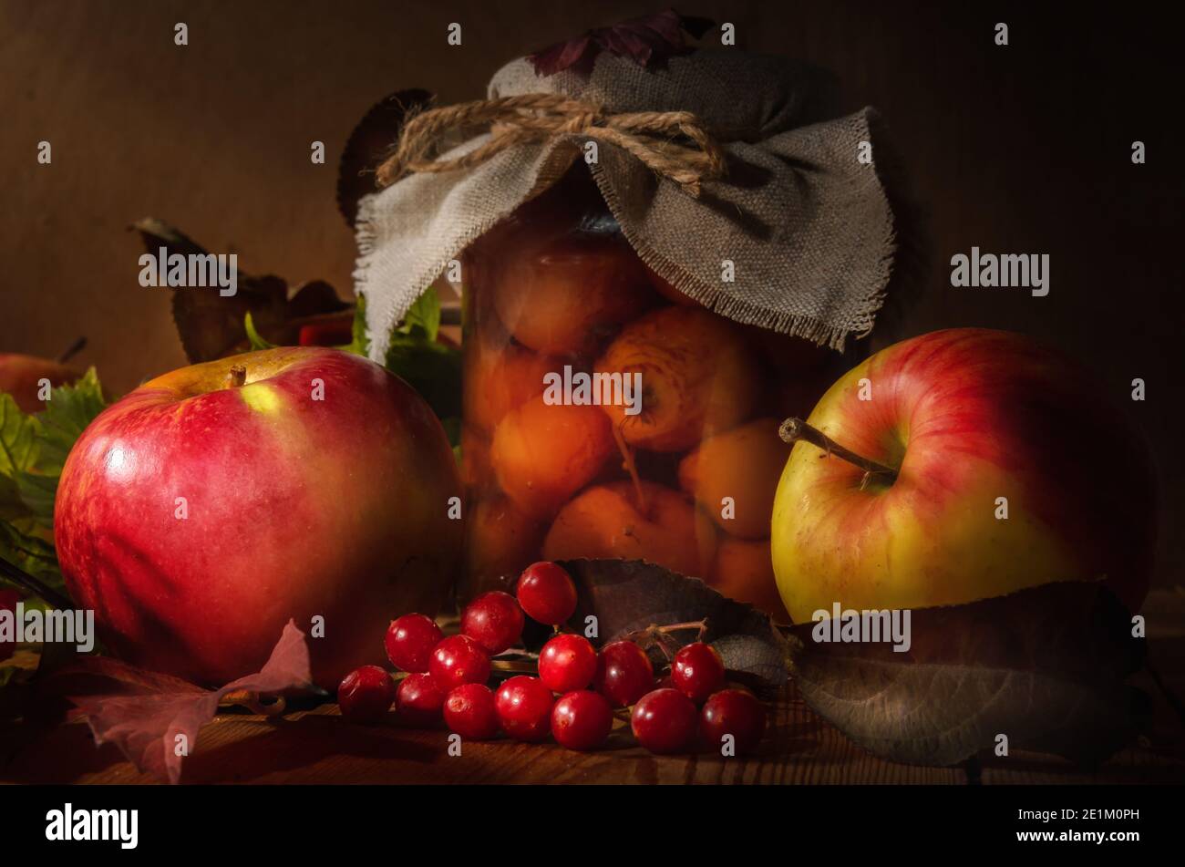 pommes et branches de viburnum sur fond de bois sombre dans un style rustique. Banque D'Images