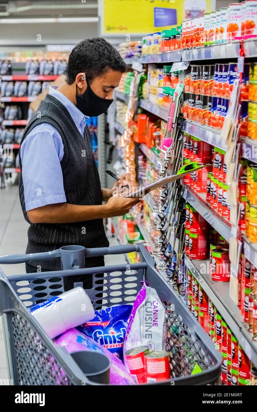 Cape Town, Afrique du Sud - 10 décembre 2020 : membre du personnel qui cueille les produits d'épicerie de l'étagère pour un service de livraison express à domicile au service local Pick n Pay su Banque D'Images