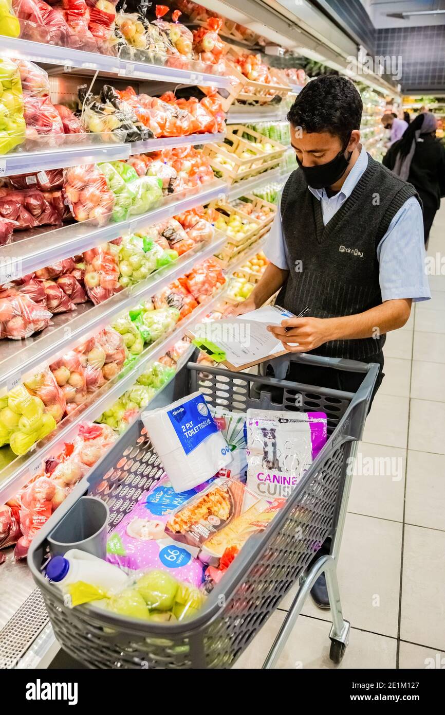 Cape Town, Afrique du Sud - 10 décembre 2020 : membre du personnel qui cueille les produits d'épicerie de l'étagère pour un service de livraison express à domicile au service local Pick n Pay su Banque D'Images