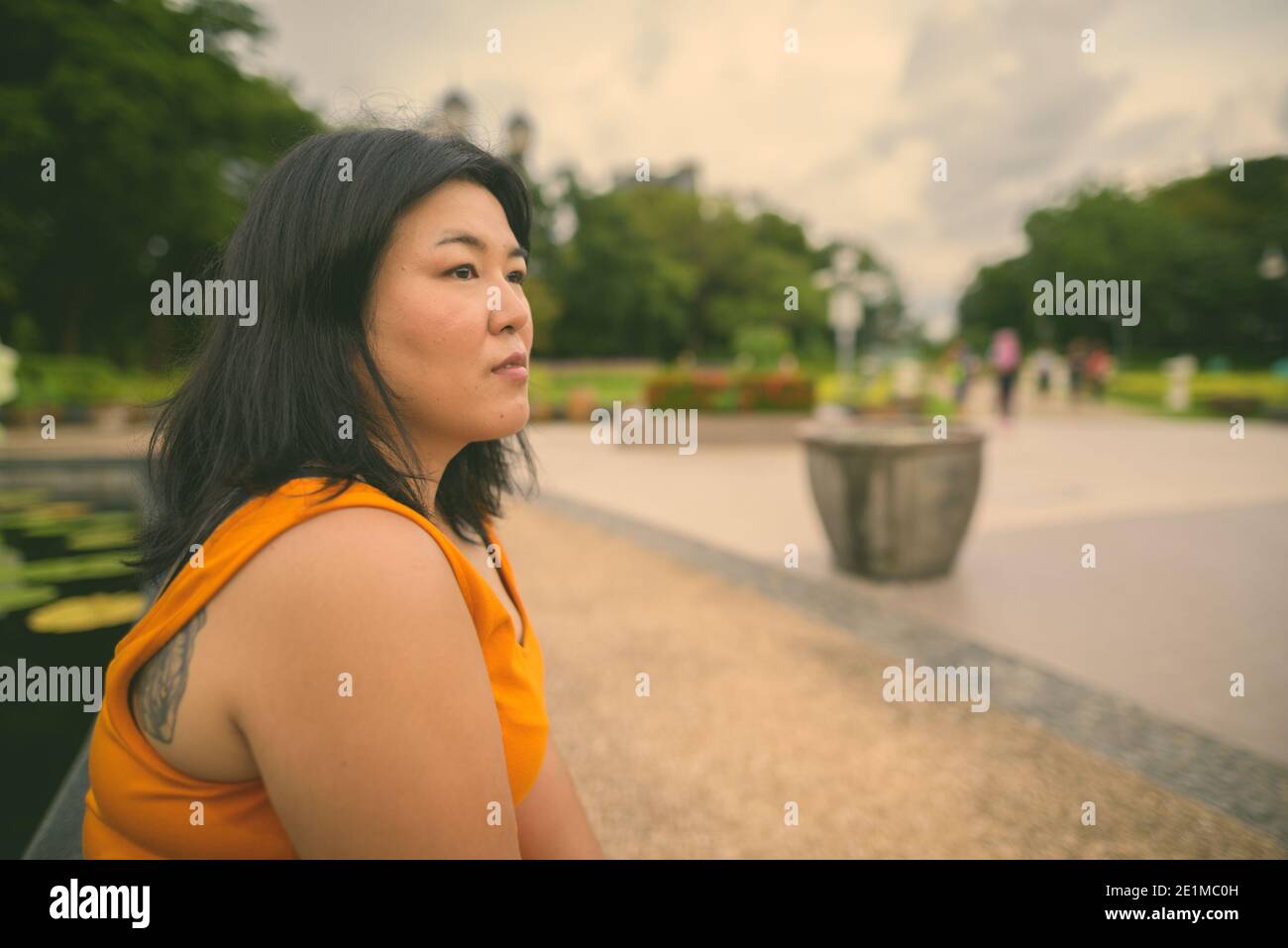 Belle femme asiatique en surpoids se détendant dans le parc de la ville de Bangkok, Thaïlande Banque D'Images